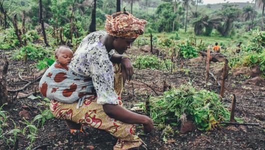 vrouw bewerkt land in Afrika