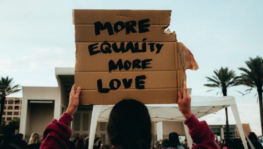 Demonstrant toont bord met "More equality More love"
